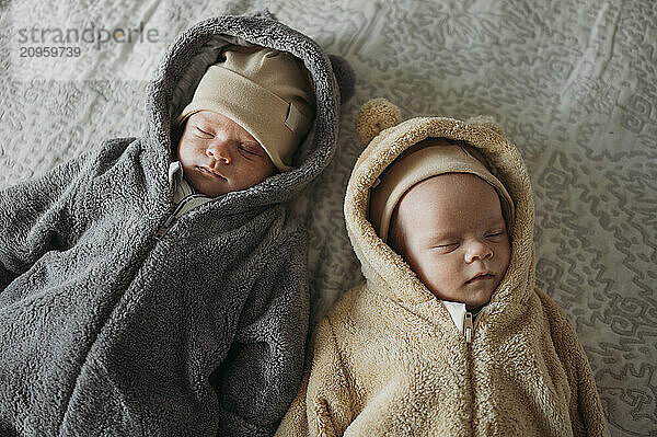 Twins sleeping on bed at home