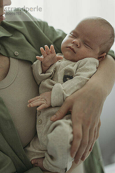 Mother holding newborn baby in arms at home