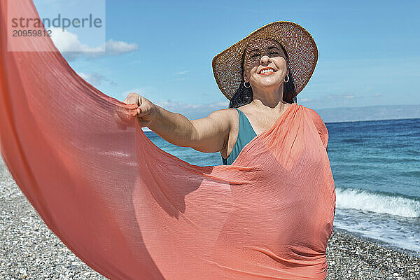 Smiling woman spending leisure time on beach near sea