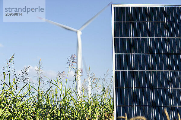 Solar panel on field with wind turbines in background