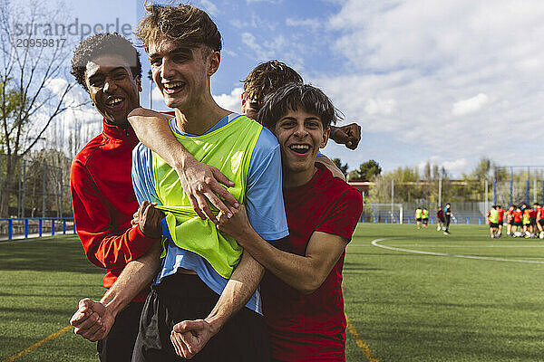 Happy soccer players celebrating victory on field