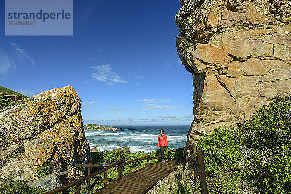 Woman walking on bridge near rock boulders at Robberg Nature Reserve in Garden Route National Park  Western Cape  South Africa