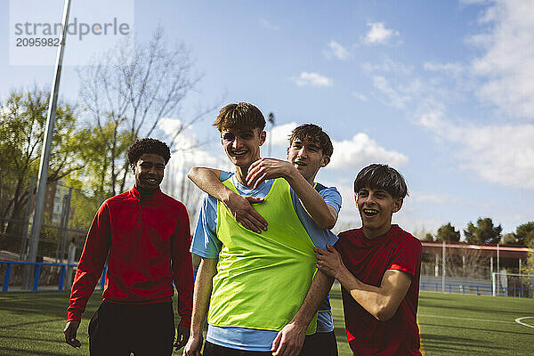 Happy soccer players winning match on sunny day