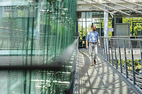 Businessman walking in corridor of modern office building