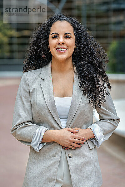 Businesswoman with hands on stomach standing near office park