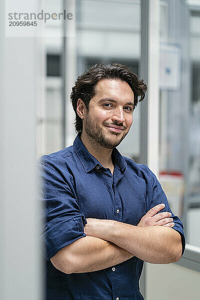 Smiling young businessman with arms crossed