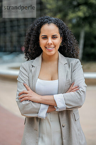 Smiling businesswoman standing with arms crossed