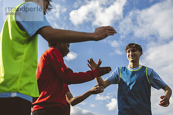 Happy soccer players giving high-five to each other