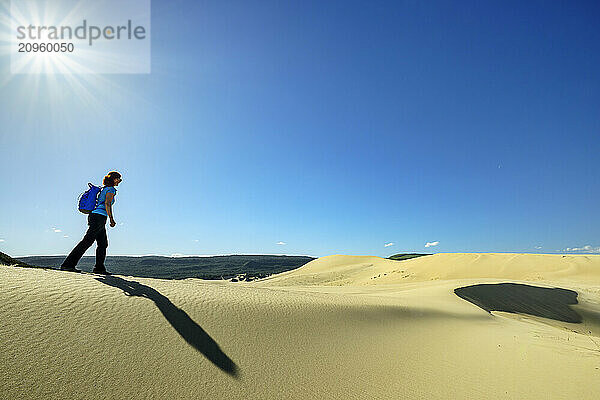 Mature woman hiking on sand dunes at sunny day in in Eastern Cape  South Africa