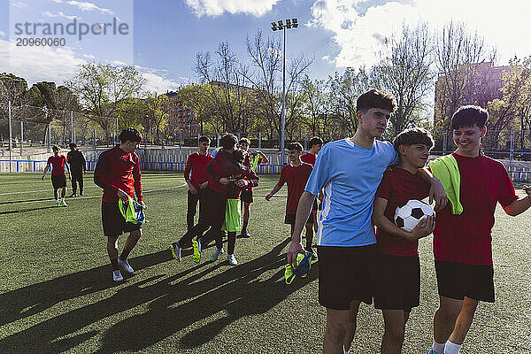 Soccer team walking on field under cloudy sky