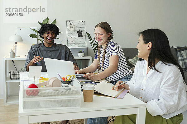 Cheerful man enjoying group study with friends at home