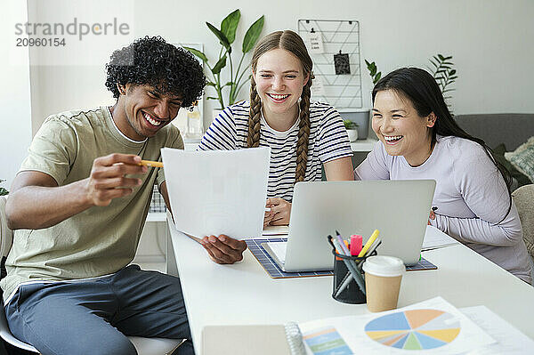 Cheerful students enjoying group study at home