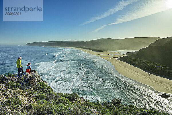 Hikers looking at beach sitting on cliff in Western Cape  South Africa