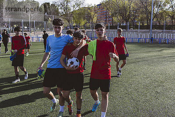 Soccer player walking with teammates on field