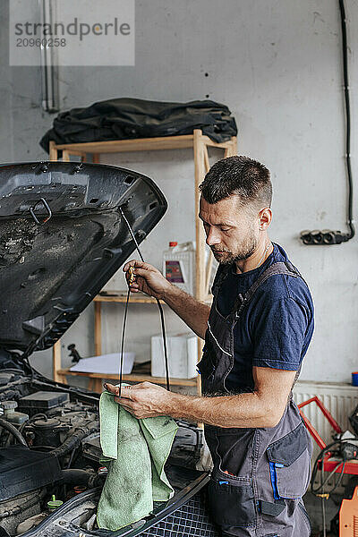 Man cleaning car with cloth in garage