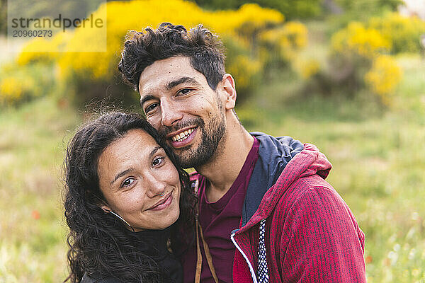 Smiling couple with cheek to cheek at park