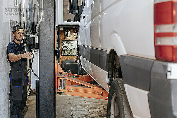 Auto expert working on vehicle maintenance inside garage