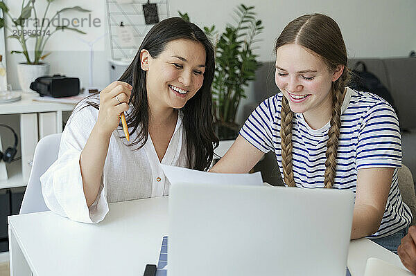 Happy friends studying at home