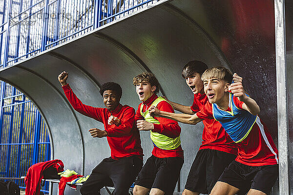 Happy soccer players cheering team on field