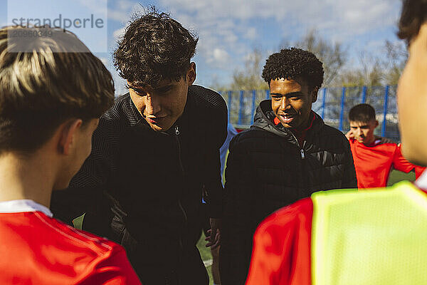 Soccer players talking to teammates on sunny day