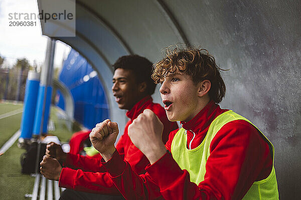 Soccer players celebrating victory goal on field