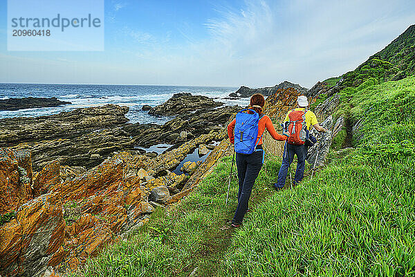 Mature travelers hiking on Otter trail near sea in Tsitsikamma Section  Garden Route National Park  Eastern Cape  South Africa