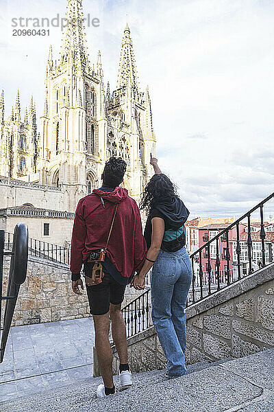 Young woman showing Bargos Cathedral to boyfriend standing on steps