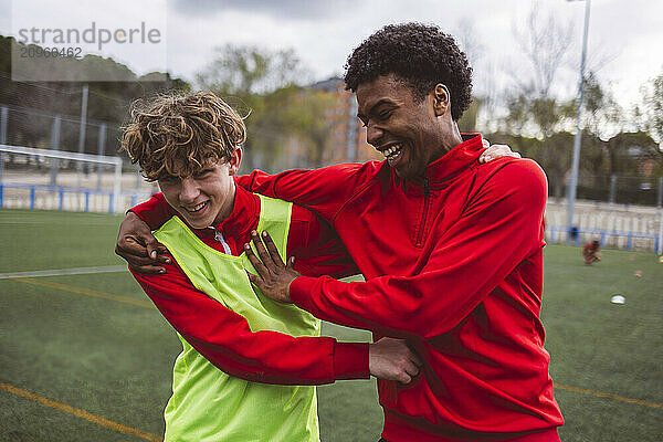 Happy soccer teammates having fun in training on field