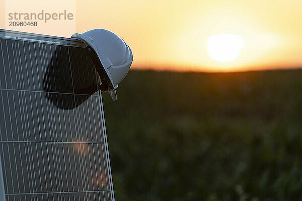 Engineer's hardhat kept on solar panel