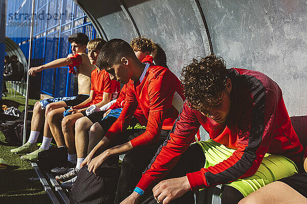 Soccer players sitting together on bench