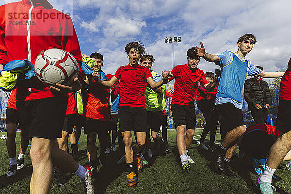 Happy soccer team winning match on field