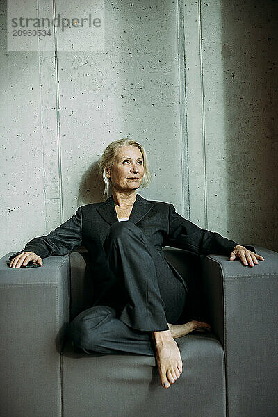 Thoughtful businesswoman sitting on chair at office