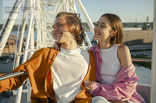 Happy couple riding on ferris wheel at amusement park