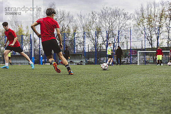 Athletes playing soccer on field