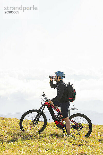 Cyclist drinking water after mountain biking