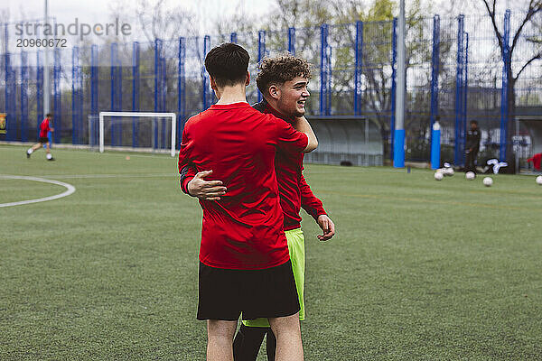 Happy soccer players celebrating success on field