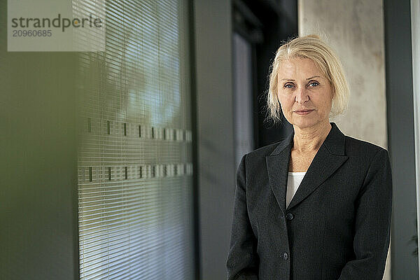 Confident businesswoman in blazer at office