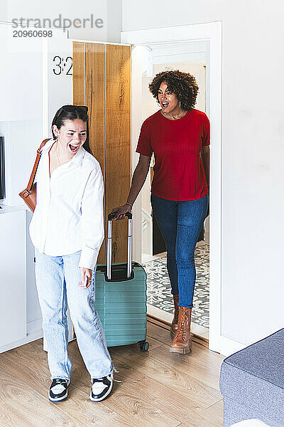 Multiracial friends looking around at rented hotel room