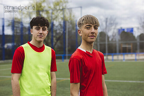 Smiling soccer players standing on field