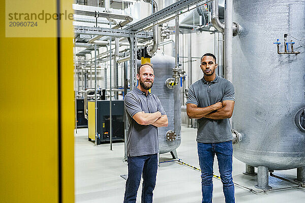 Portrait of two confident employees in factory