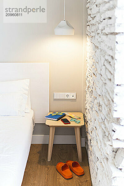 Illuminated room with stool and bed in hotel