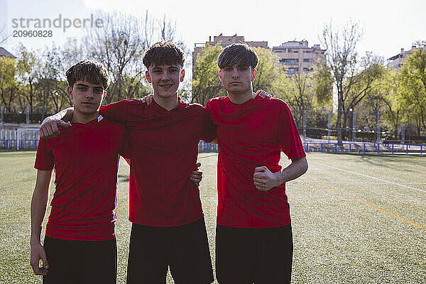 Smiling soccer players standing on field