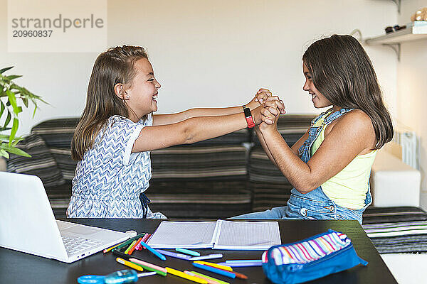 Friends holding hands and playing at home