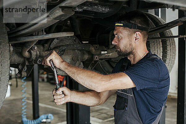 Expert mechanic works meticulously on vehicle repair in garage