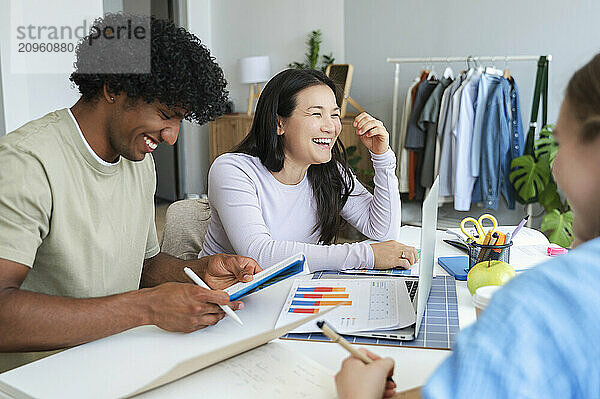 Happy young woman doing project with friends at home