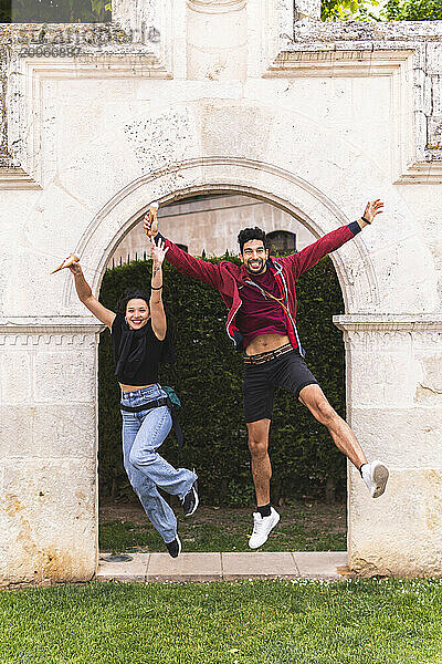 Cheerful couple holding ice cream and jumping on vacations