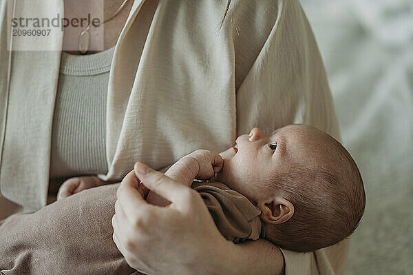 Mother carrying newborn baby boy in arms