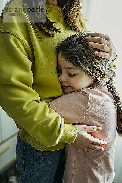 Girl embracing mother at home