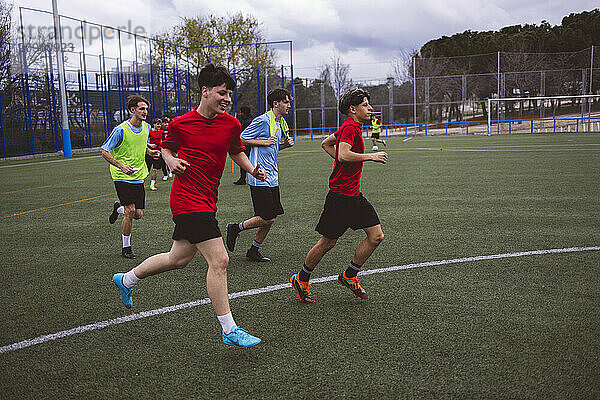 Happy soccer team playing match on field