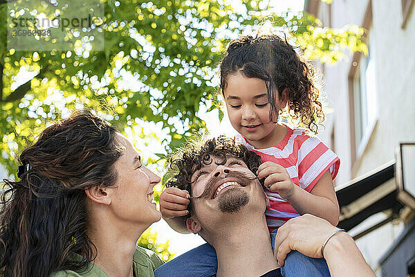 Happy mother and father enjoying with daughter